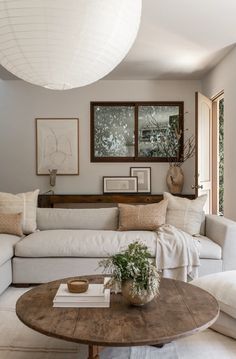 a living room with couches, tables and pictures hanging on the wall above them