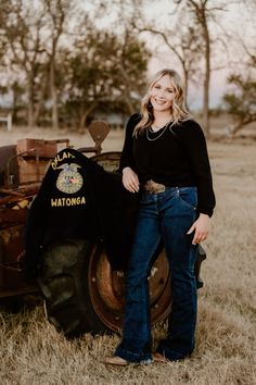 a woman standing in front of an old tractor with a national police shirt on it