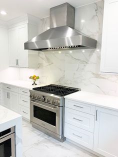 a stove top oven sitting inside of a kitchen next to white cupboards and counter tops