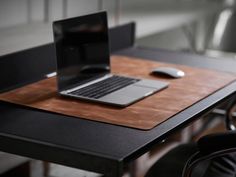 a laptop computer sitting on top of a wooden table next to a mouse and keyboard