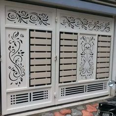 a motorcycle parked in front of a white building with decorative designs on it's doors