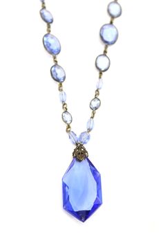 Absolutely stunning light cobalt blue Edwardian pendant necklace will turn heads at your next period style dress up affair!  The antique necklace is comprised of a 1 3/4" faceted blue glass pendant, with a bead and chain strand. It has silver wrapped blue glass sections. I think it is sterling but still trying to make out the mark on the spring ring.  It is in fab condition, though I think I can feel a tiny chip( maybe?) It cant be seen without a magnifying glass.  This type of jewelry always ma Formal Blue Faceted Necklaces, Formal Blue Faceted Necklace, Blue Art Deco Necklace For Formal Occasions, Victorian Style Blue Necklaces For Formal Occasions, Art Deco Blue Pendant Necklace, Victorian Blue Necklaces For Formal Occasions, Blue Victorian Necklace For Formal Occasions, Antique Blue Necklaces For Formal Occasions, Silver Necklace With Blue