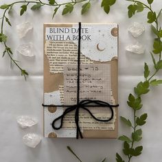 a book wrapped in brown paper and tied with a black string, surrounded by flowers