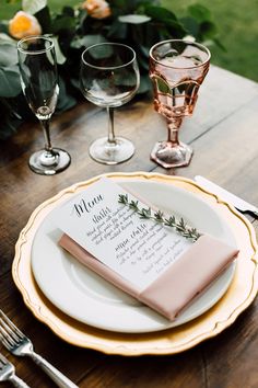 a place setting with wine glasses and napkins