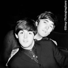 two young men are posing for a black and white photo, one is holding his arm around the other's shoulder