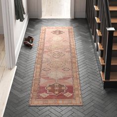 a hallway with a rug on the floor and stairs