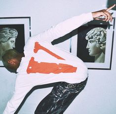 a man doing a trick on a skateboard in front of two framed pictures and one pointing to the side