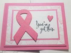 a card with a pink ribbon on it