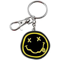 a black and yellow smiley face keychain on a white background with a clipping