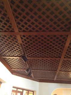 the ceiling in this living room is made out of wood and has lattice designs on it