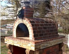 an outdoor brick oven with a statue on top