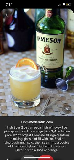 a bottle of jameson on top of a table next to a glass with an orange slice