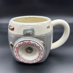 a coffee cup with a camera on the inside is shown in close up view, it appears to be made out of porcelain