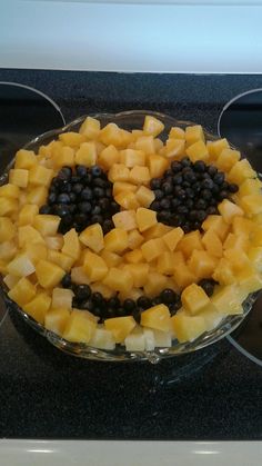 a glass dish filled with fruit on top of a stove