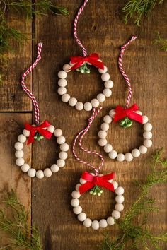 christmas decorations made out of beads and candy canes on a wooden table with greenery