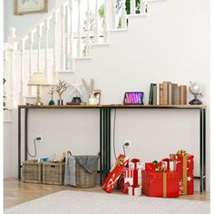 christmas presents under the banisters in front of a stair case with books on it