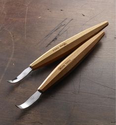 two wooden knives sitting on top of a table