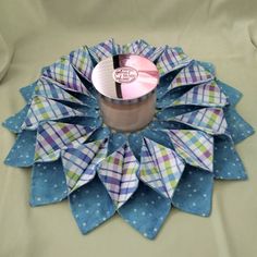 a coffee cup sitting on top of a blue and white paper flower with polka dots