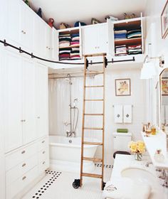 a bathroom with a ladder in the middle of it's storage area and a sink