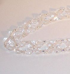 "This beautiful necklace will look stunning on any bride. Made with clear Swarovski crystal biconesand silver-lined glass seed beads. I can make it using any combination of Swarovski colors and seed beads to match your wedding motif. A matching bracelet is also available. We can work together to make it exactly the way you want it for your special day. Comes in a pretty gift box. The length showing here is 16\" with a toggle clasp that can be changed to a lobster claw clasp with an extension so Clear Sparkling Jewelry For Wedding, Sparkling Clear Jewelry For Wedding, Elegant Beaded Clear Crystal Bracelet, Elegant Crystal Bracelet With Clear Round Beads, Elegant Clear Beaded Crystal Bracelet, Wedding Crystal Jewelry With Faceted Details, Faceted Round Crystal Bracelet For Weddings, Faceted Crystal Bracelet For Weddings, Elegant Crystal Necklace With Spacer Beads