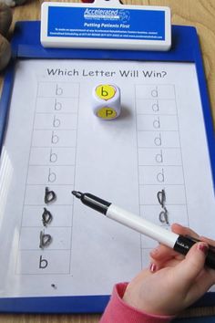 a person is writing on a clipboard with letters and numbers in front of them