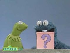 the sesame street characters are standing in front of a question box and one is holding a cell phone