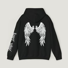 Elevate your style with our black hoodie featuring striking white Angel wings graphic on the back, exuding celestrial vibes. Embrace angelic energy with intricate writing on the sleeve. This classic fit hoodie offers comfort in a thick blend of cotton and polyester, complimented by a color matched drawstring and double-lined hood. Complete with complete with a pouch pocket and tear-away label for a trendy versatile look. Memorial Hoodie Ideas, White Hooded Grunge Hoodie, White Grunge Hooded Hoodie, White Hooded Grunge Sweatshirt, White Grunge Hoodie Sweatshirt, Edgy White Winter Sweatshirt, White Grunge Hoodie For Streetwear, Edgy White Sweatshirt For Streetwear, White Sweatshirt With Back Print For Streetwear