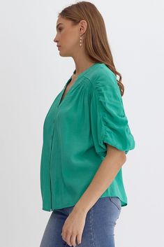 Jade Green Short Sleeve Button Up Top Designed with a v-neckline with button front, smocking and seam details throughout, and 1/2 length sleeves with elastic. This versatile top can be dressed up or worn casually! Button front V-neckline Smocking Seam detail Elastic at sleeve 1/2 length sleeve Pintuck detail at front Woven Lightweight Fabric Content: 80% Rayon / 20% Tencel Fit: True to size Model is 5'10" wearing a size small Sizing: S: 0-6, M: 8-10, L: 12-14 Green Short Sleeve Top With Button Closure, Purple Short Sleeve Top With Button Closure, Green Button-up Tops With Pockets, Green Summer T-shirt With Button Closure, Green Top With 3/4 Sleeves And Button Closure, Button Up Top, Green Shorts, Short Sleeve Button Up, Pin Tucks