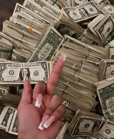 a person is pointing at money with one finger and the other thumb on top of it