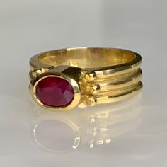 A simple and elegant vintage east/ west ring featuring a candy colored oval shaped ruby weighing 1.15 carats set in solid 14k yellow gold with a bezel setting which elevates the stone above the finger. *Ring size: 6 1/2 *Ring weight: 5.21 grams *Complimentary resizing is available up to 3 sizes larger or smaller than stated size. Modern Gold Oval Ruby Ring, Modern Oval Ruby Ring In Gold, Modern Oval Gold Ruby Ring, Classic Oval Gemstone Ring, Classic Oval Ruby Ring In Yellow Gold, Oval Hallmarked Ruby Ring In Yellow Gold, Hallmarked Oval Ruby Ring In Yellow Gold, Oval Yellow Gold Ruby Ring Hallmarked, Oval Ruby Ring Fine Jewelry