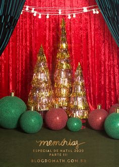 christmas decorations with red and green balls in front of a red curtained stage backdrop