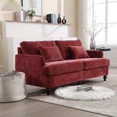 a red couch sitting on top of a white rug