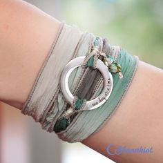 "This Steel and Silk Wrap bracelet features a Steel ring with an engraving that reads \"one day at a time.\" The ring measures 20 mm (approximately .75 inches) in diameter and is attached to silk ribbon that measures 38 inches (approximately 96.5 cm) in length. The hand dyed silk ribbon is sewn on the edge to prevent fraying and attached with Sterling Silver wire. Silk Wrap Bracelets are easy to wear. Just wrap the silk ribbon around your wrist, slide the ring where you want it, and tie the ribb Bohemian Silver Personalized Bracelets, Bohemian Silver Hand Stamped Bracelets, Bohemian Hand Stamped Jewelry, Bohemian Hand Stamped Jewelry For Everyday, Bohemian Personalized Bracelets For Friendship, Personalized Bohemian Bracelets For Friendship, Bohemian Nickel-free Wrap Bracelet As Gift, Silver Bohemian Beaded Bracelets Personalized, Bohemian Personalized Bracelet