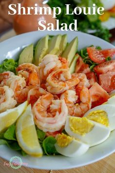 shrimp and avocado salad on a white plate with the words shrimp louie salad