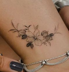 a close up of a person's foot with flowers on it and chains around the ankles