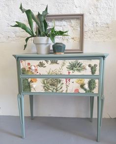 a green painted dresser with plants on it