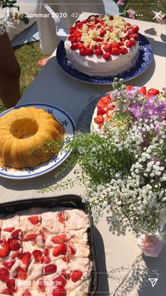 there are many desserts on the table and one is white with strawberries in it