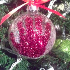 a red ornament hanging from a christmas tree