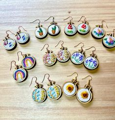 a collection of embroidered earrings sitting on top of a wooden table