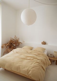 a bed sitting in a bedroom next to a window with a lamp on top of it