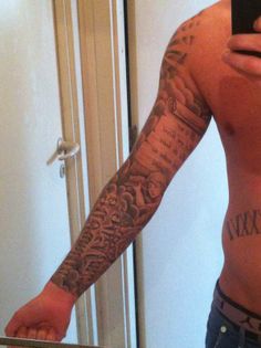 a man is taking a selfie in the mirror with his cell phone and tattoos on his arm