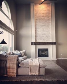 a living room filled with furniture and a fire place in front of a large window