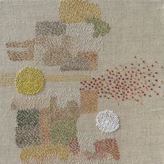 an embroidered piece with many different colors and shapes on the fabric, including circles and dots