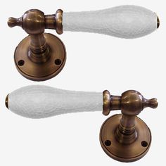 two white glass knobs on the handles of an antique style door handle and cover