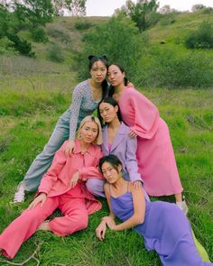 four women pose for a photo in the grass