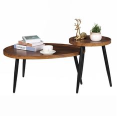 two wooden tables with black legs and some books on top of them in front of a white wall