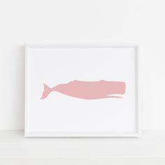 a pink silhouette of a fish on a white wall above a shelf in a room