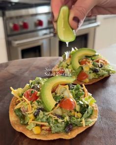 an avocado is being drizzled on top of a tortilla