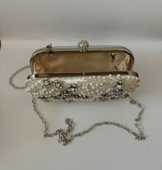 The Pearl Purse is a stylish blend of sophistication and glamour. It is crafted with precision and attention to details. This beaded purse is a must have addition to your accessory collection. It will glamorize your look and is spacious enough to carry all the essentials. The clutch comes with a detachable chain strap so you can carry it as a clutch or a shoulder & crossbody bag. Dimensions: (LxHxW): 7.5 inches x 4.7 inches x 1.97 inches Material: Pearls and Beads, Satin, Rhinestones Features: K Luxury Beaded Handheld Evening Bag, Luxury Handheld Beaded Evening Bag, Luxury Pearl Clutch For Party, Elegant Pouch Bags As Fashion Accessory, Glamorous Clutch With Pearl Embroidery, Luxury Evening Bag With Pearl Embroidery For Parties, Chic Pearl-embellished Clutch For Formal Occasions, Chic Pearl Clutch For Formal Occasions, Pearl Beaded Evening Bag For Formal Occasions