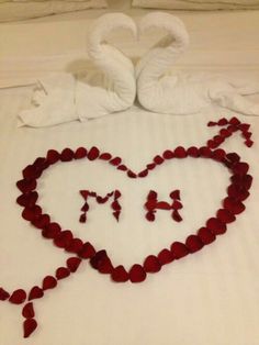 two swans made out of hearts on a bed with the word i love you written in it